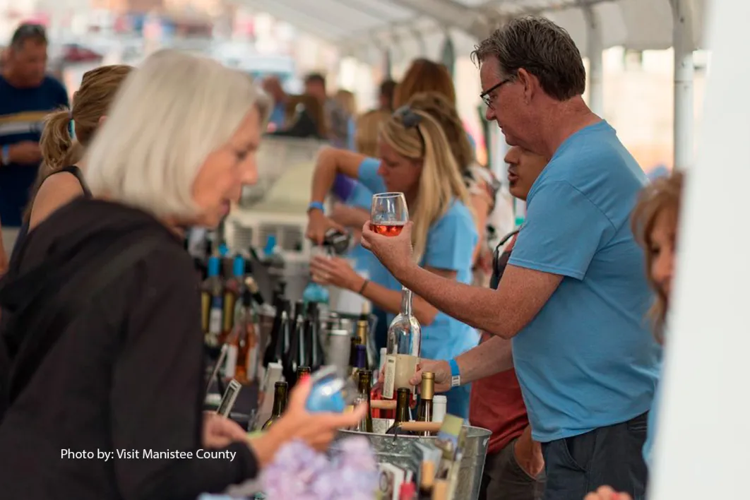 Pouring wine at Grapes on the River wine tasting festival in Manistee Michigan