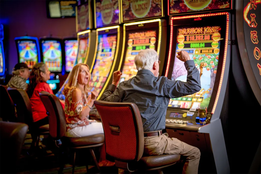 man with white hair celebrating at slot machine